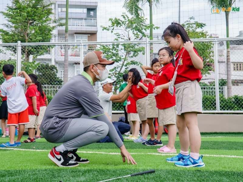 Huấn luyện viên hướng dẫn các em học sinh luyện tập đánh golf